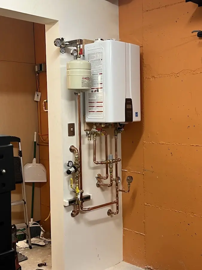 Plumbing technician inspecting water heater connections in Carpinteria